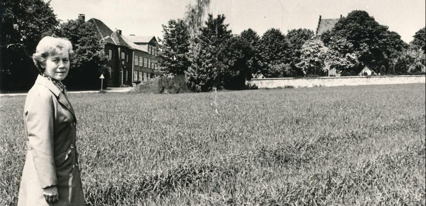 Menighedsrådsformand Martha Madsen (dengang Lundgård Jacobsen) viser, hvor den ny kirkegård skal placeres, 1973. ""